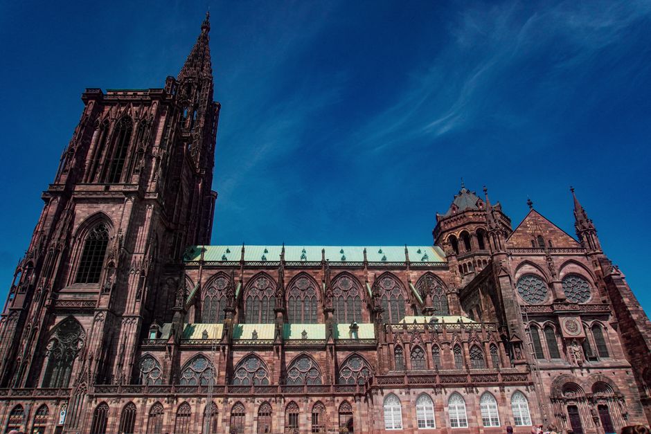 A striking view of Strasbourg Cathedral, showcasing its Gothic architecture against a clear blue sky.