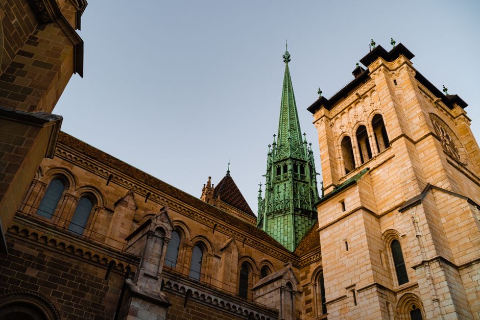 Stunning low angle shot of a historic cathedral's architecture and spire against a clear blue sky.